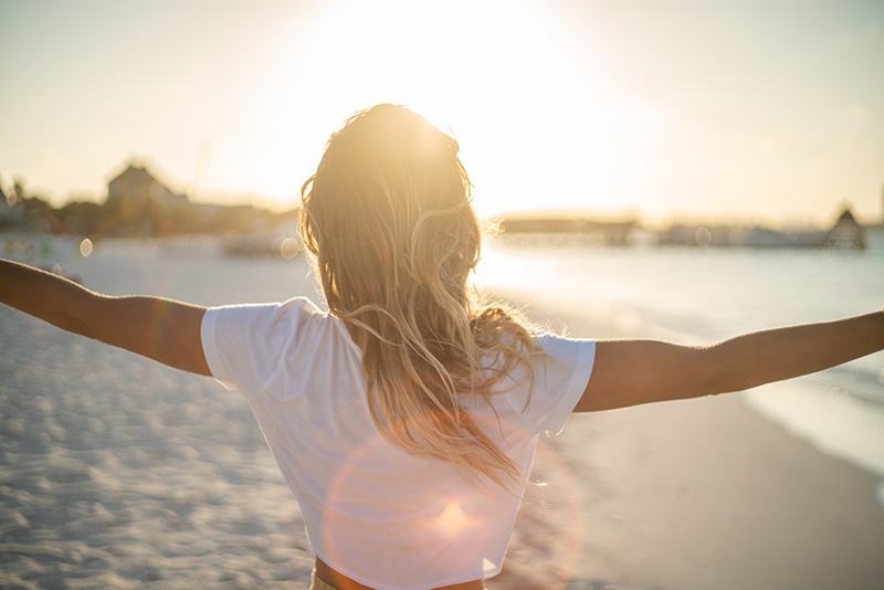 Cheerful young woman embracing nature