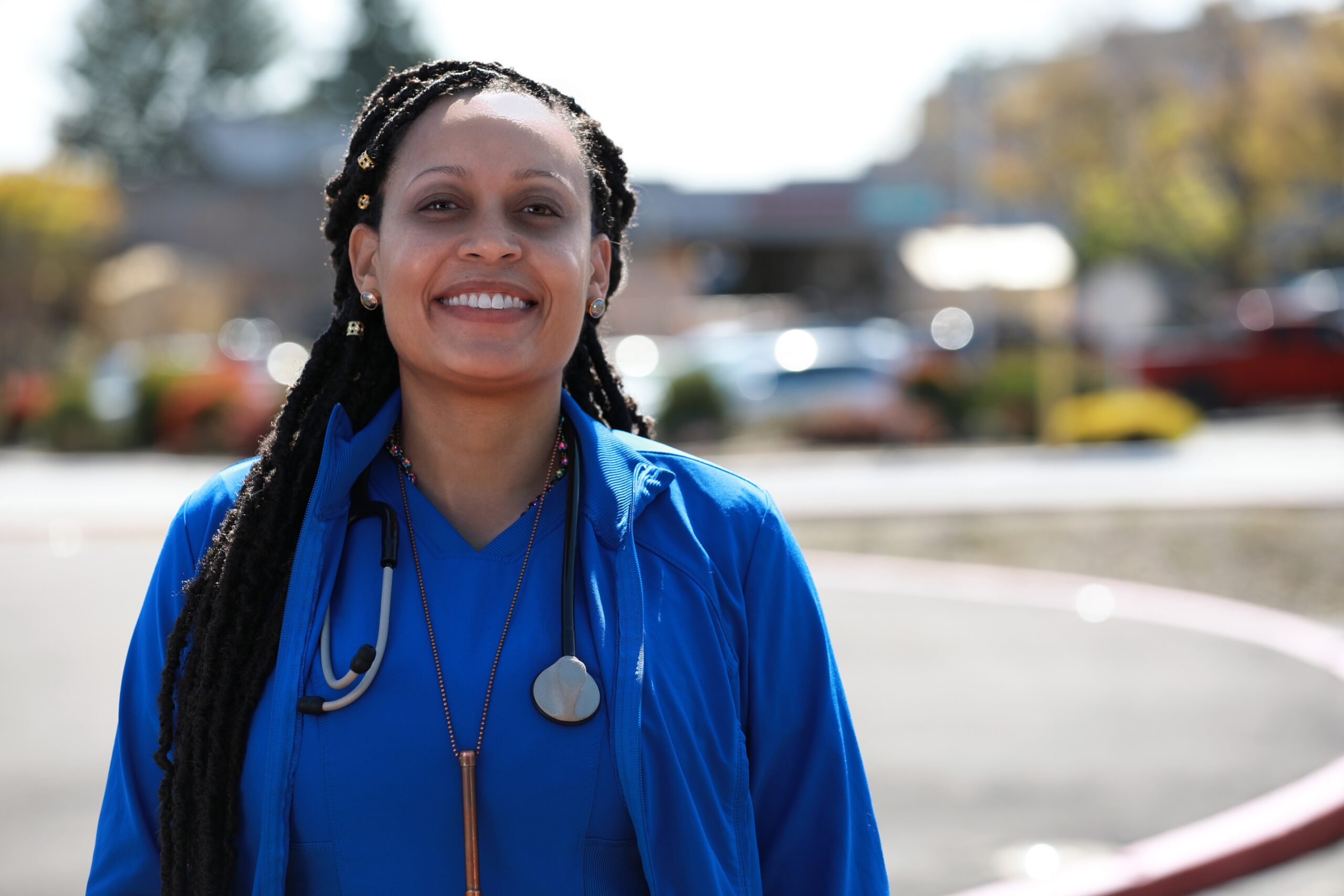 Nurse Ashley smiling outside in scrubs