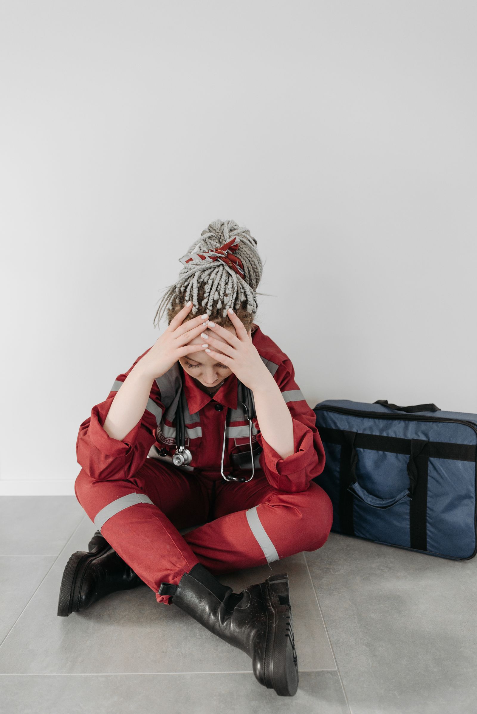 Tired nurse sitting on the floor, carrying the weight of the shift