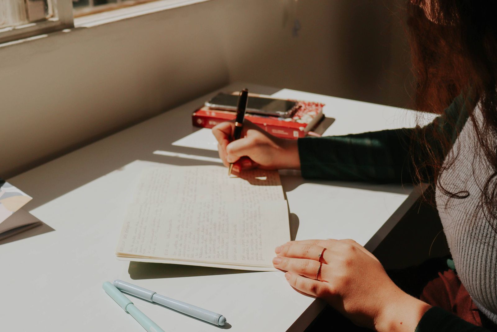 Woman journaling in morning light during a quiet moment of reflection